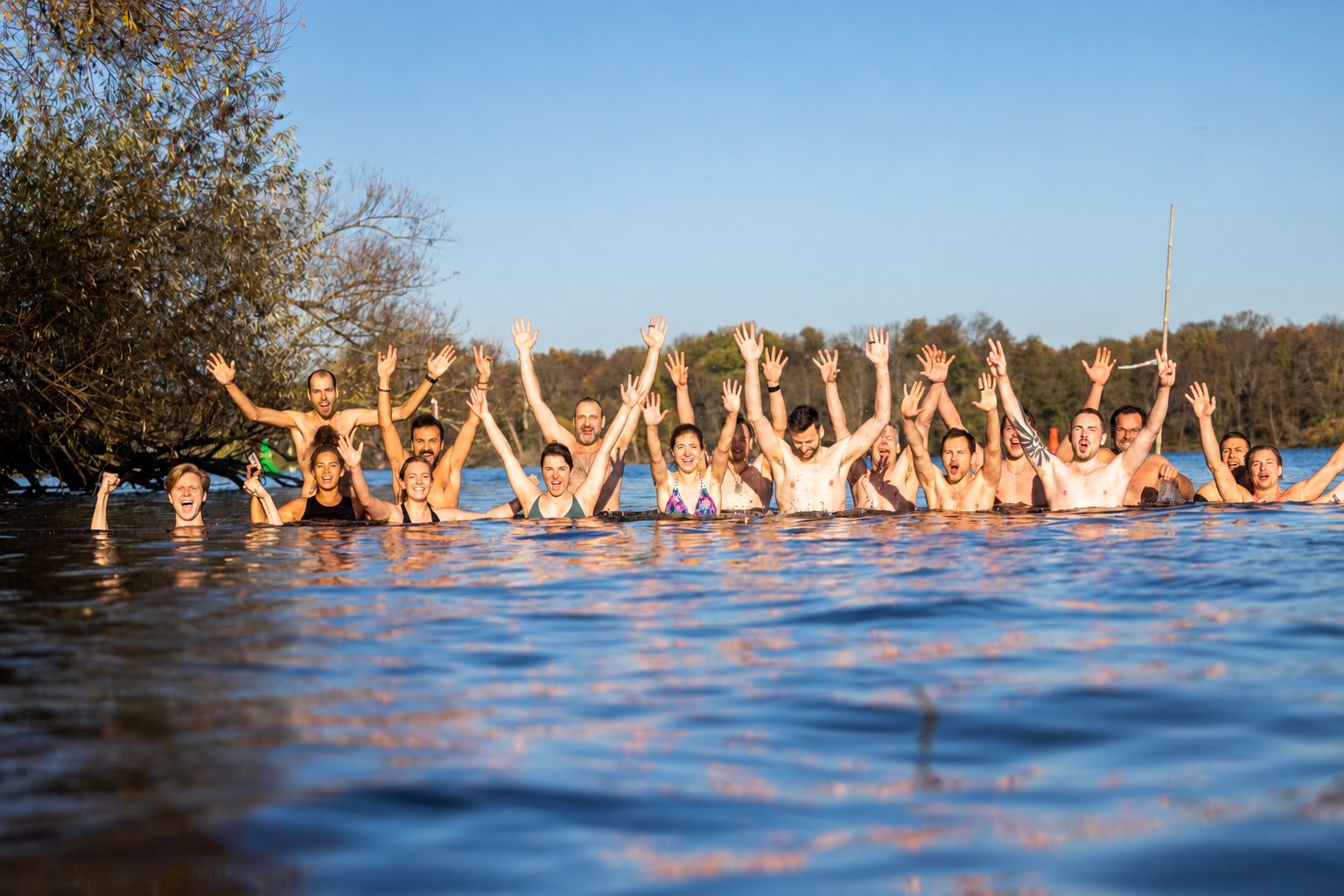 Participants raising their hands together in a lake at an earlier Inspiration Days.